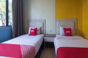 Two single beds with white headboards and red pillows, a small bedside table, and a window with curtains. - Hotel O Hotel 916 (Batu Caves)