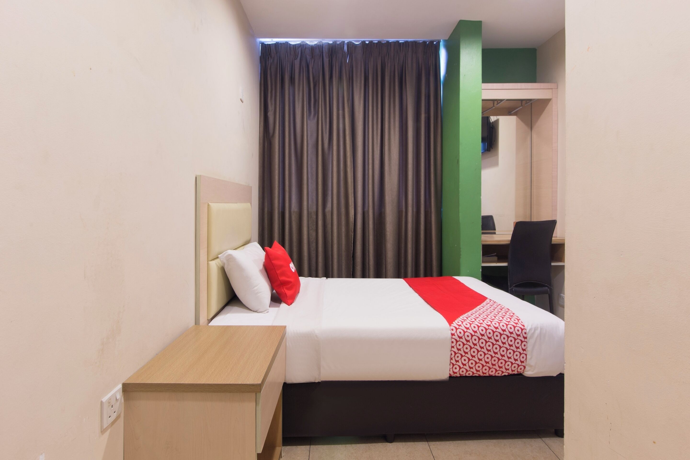 A hotel room with a bed, a desk, and a chair.