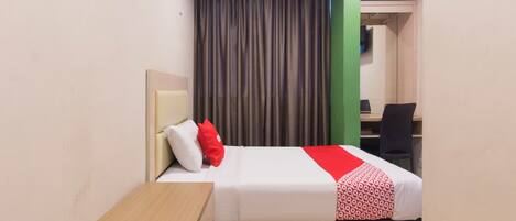A hotel room with a bed, a desk, and a chair.