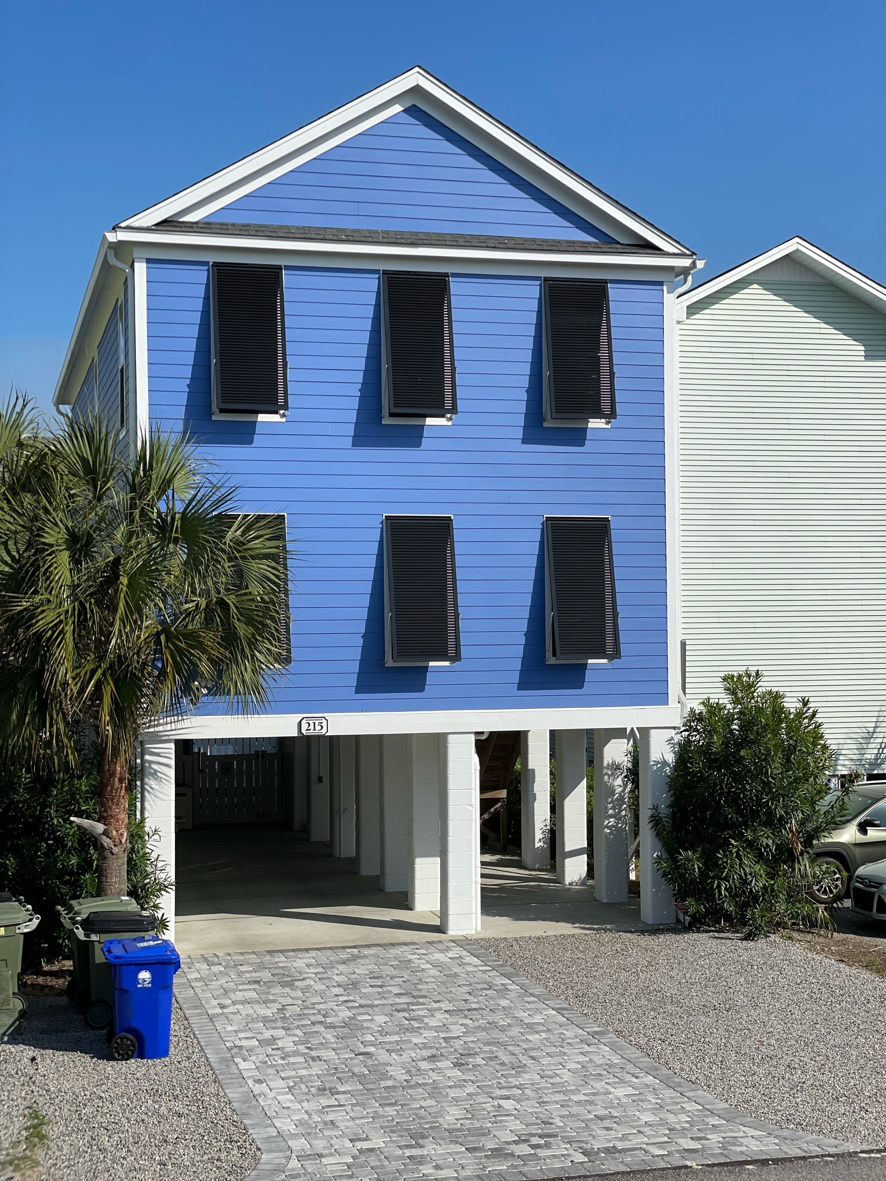 A two-story building with a blue exterior and white trim, featuring a covered entrance and a visible address number.