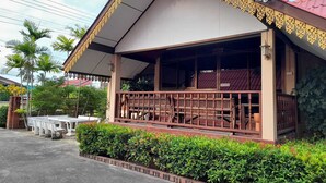 A building with a covered porch, a red roof, and a decorative yellow trim. - Sukthawee (Prachuap Khiri Khan)