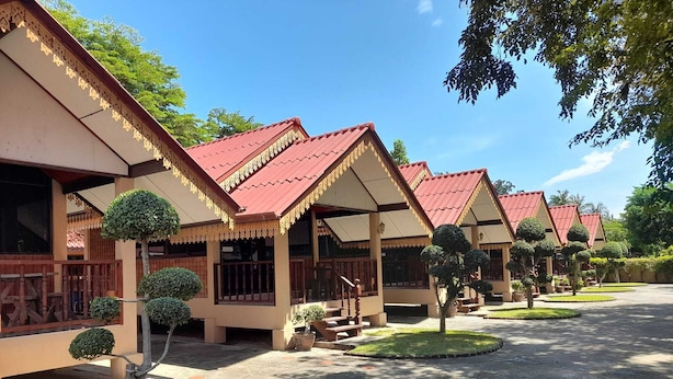 A row of traditional-style buildings with red roofs and white walls, surrounded by well-maintained lawns and trees. - Sukthawee (Prachuap Khiri Khan)