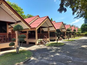 A row of traditional-style buildings with red roofs and white walls, surrounded by well-maintained lawns and trees. - Sukthawee (Prachuap Khiri Khan)