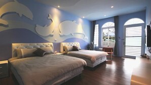 Une chambre avec deux lits, une grande fenêtre et une fresque murale représentant des dauphins.