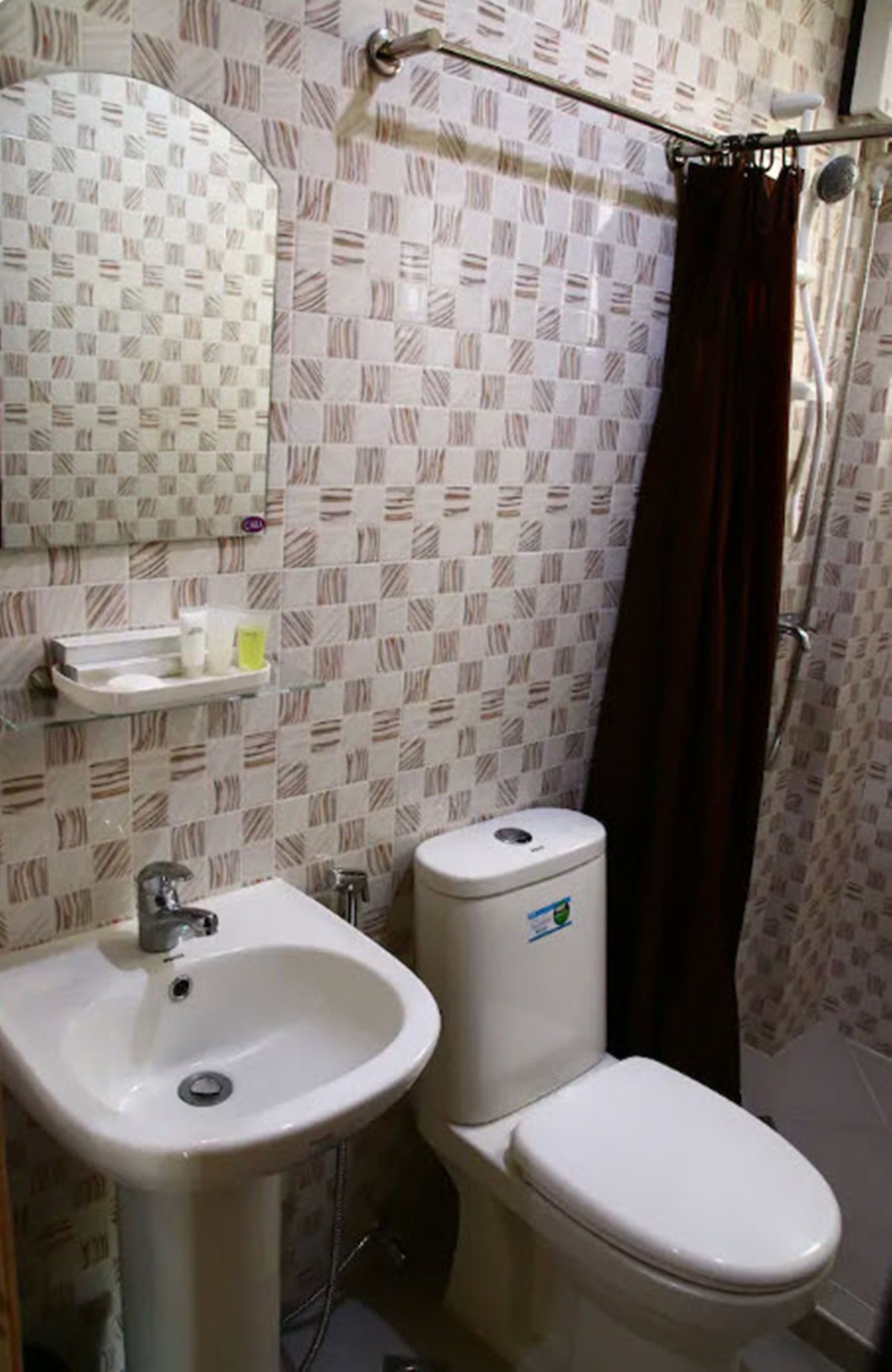 A bathroom with a sink, toilet, and shower curtain.