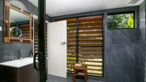 A modern bathroom with a white sink, a large mirror, and a wooden stool. - Tropical 3 Bedroom House, Pool plus 4th Bedroom Bungalow (Whitfield)
