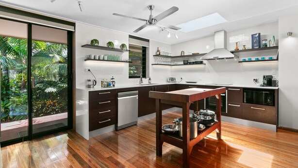 A modern kitchen with a central island, built-in appliances, and a large window overlooking greenery. - Tropical 3 Bedroom House, Pool plus 4th Bedroom Bungalow (Whitfield)