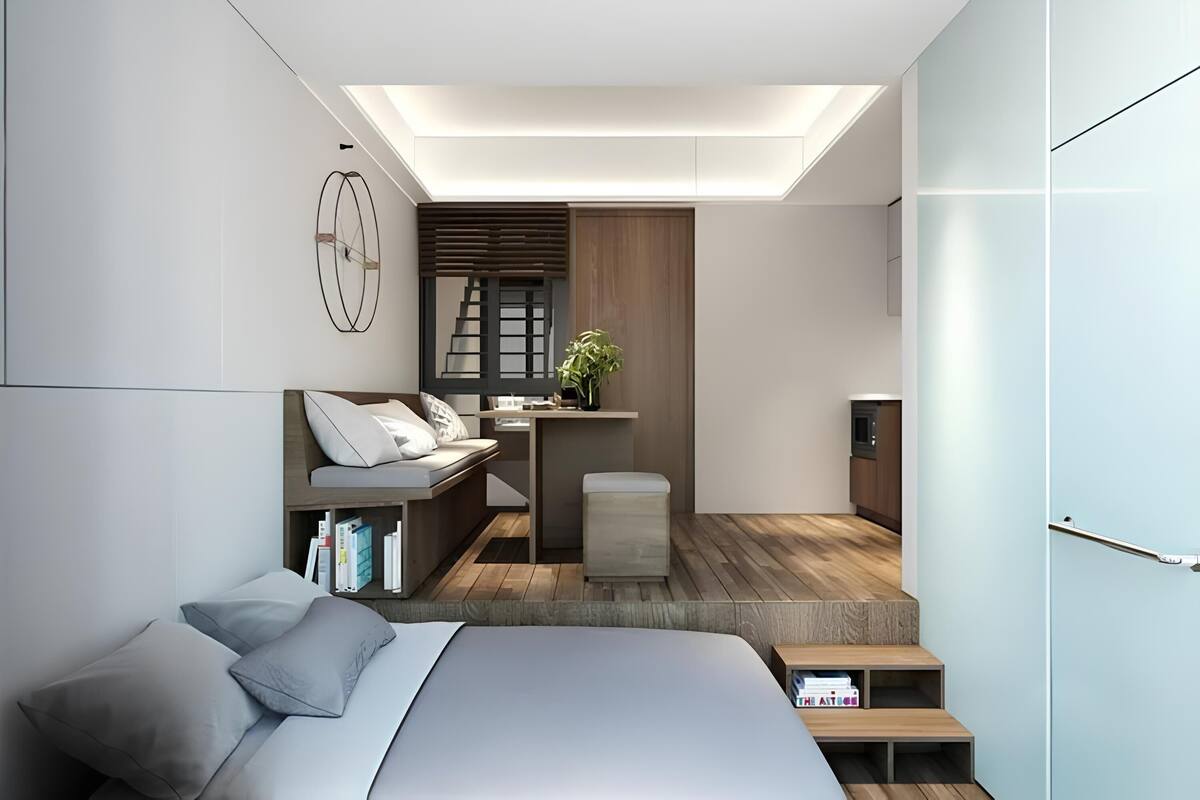 Un dormitorio moderno con cama, mesita de noche y un pequeño espacio de escritorio.