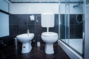 Un baño moderno con inodoro, bidé y ducha.