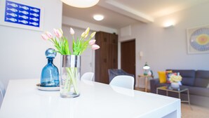 A modern living room with a white table, a vase with flowers, and a blue bottle. - Apartment Franco (Split)