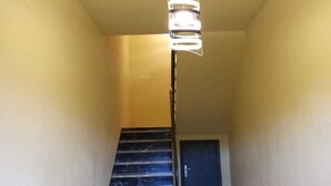 Una escalera con una lámpara moderna y un suelo estampado.