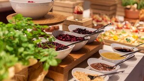 A buffet with various food items including bowls of berries, a bowl of soup, and a bowl of chocolate spread.