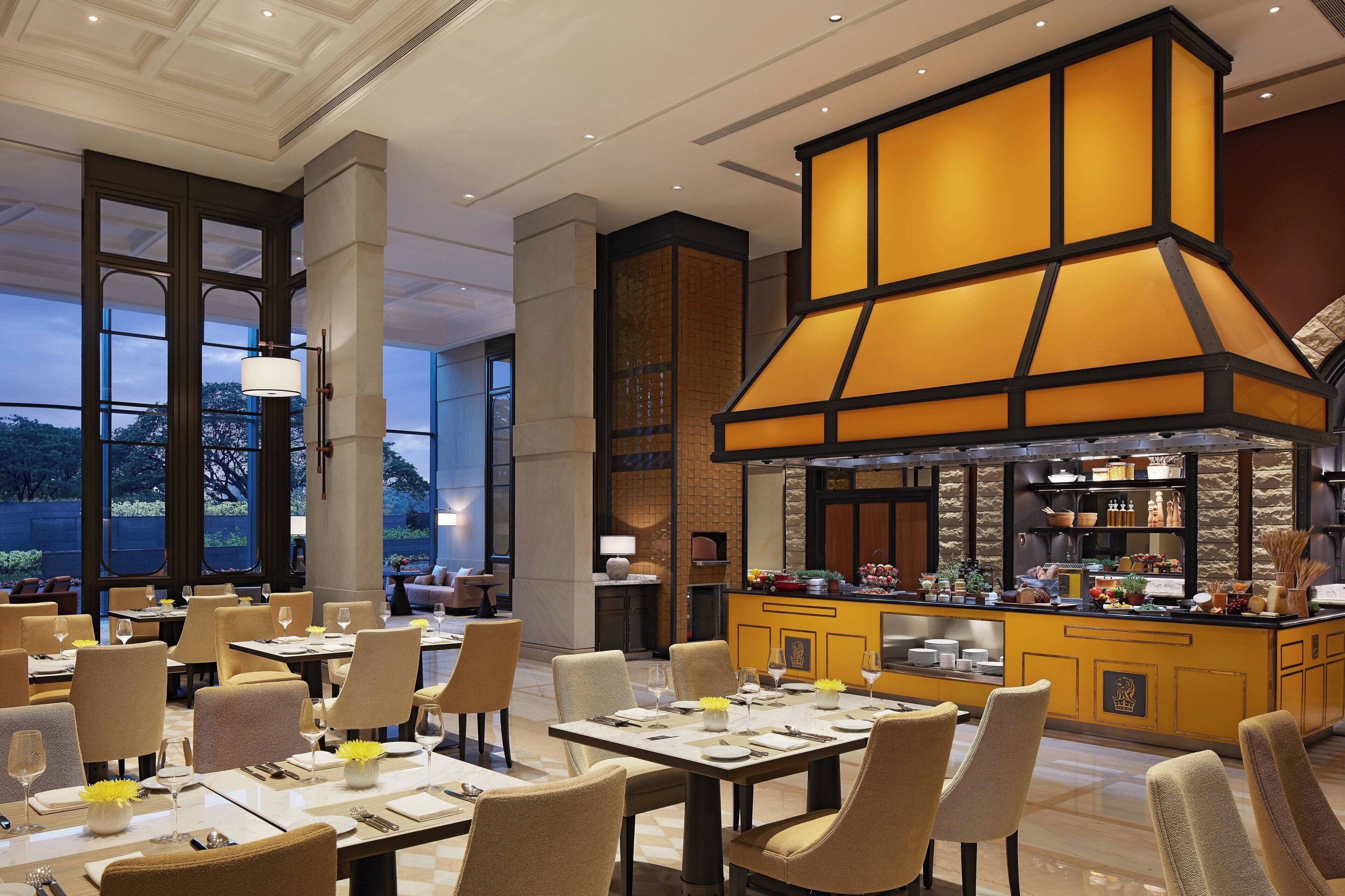 A restaurant with a central bar area, multiple dining tables, and chairs.
