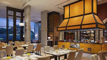 A restaurant with a central bar area, multiple dining tables, and chairs.