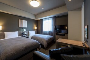 Relax in a stylish room with two single beds, a flat-screen TV, and a comfortable workspace.