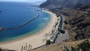 A coastal road with a beach and mountains in the background. - Casa Sirena (Santa Cruz de Tenerife)