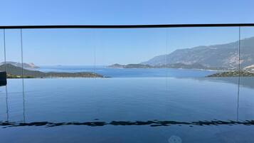 Une vue dégagée sur une mer calme, avec une terre et des montagnes qui se dessinent à l'horizon.