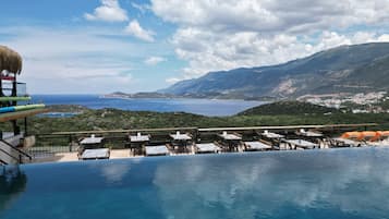 Una piscina infinita con vista al mar y a las montañas.