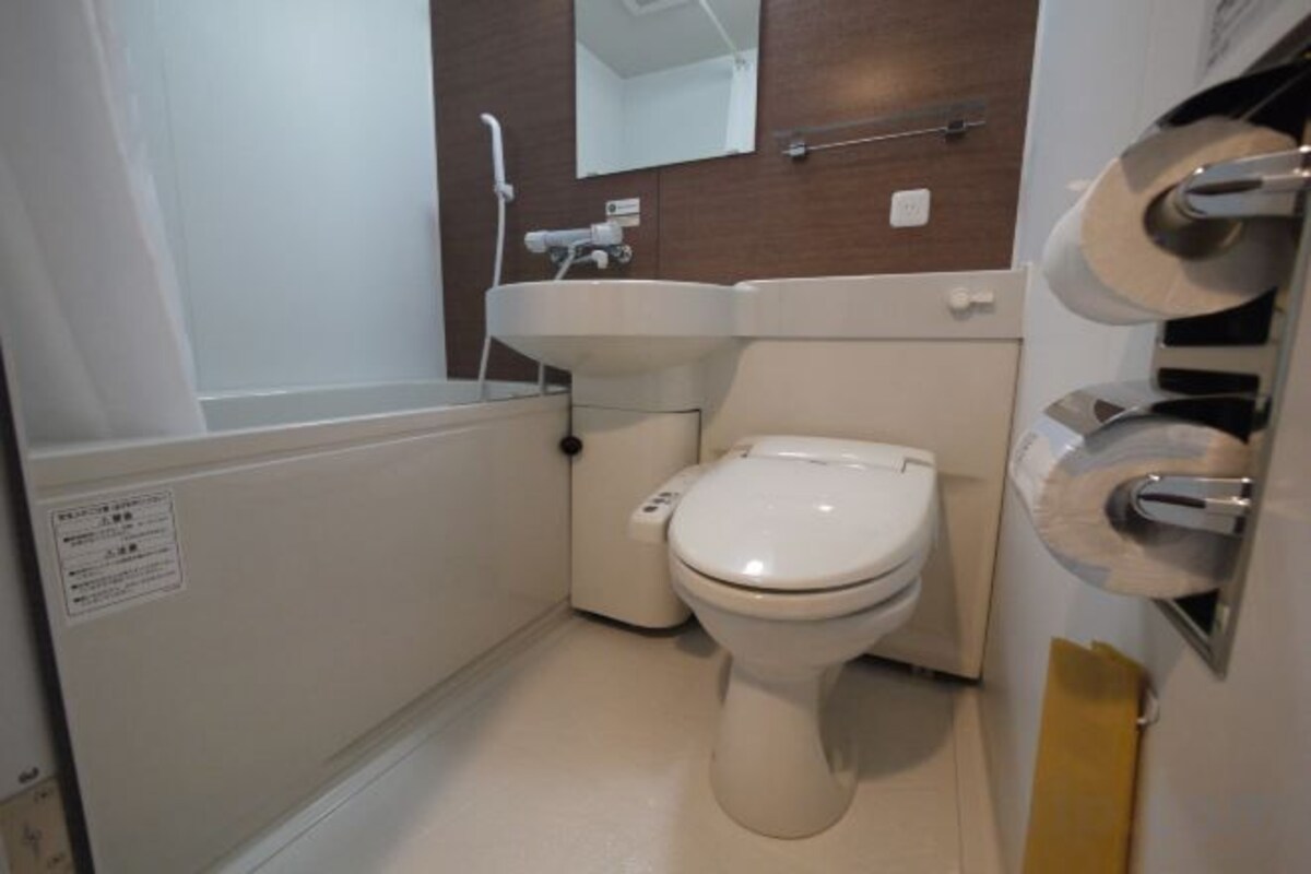A small bathroom with a toilet, sink, and shower.