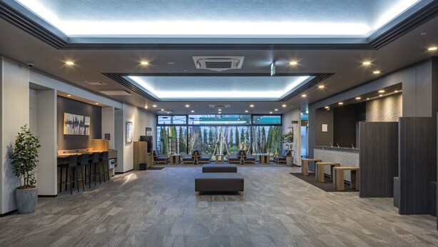 Um hall amplo com área de estar central, balcão de recepção e bar.