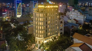Un hotel de diversos pisos amb un cartell ben visible que diu "LA BEACH HOTEL".