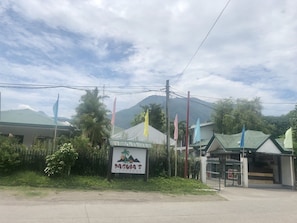 A sign for Pagua's Cottages with a mountainous backdrop. - Paguia's Cottages (Mambajao)