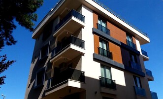Un edificio de varios pisos con balcones, ventanas amplias y un estilo arquitectónico moderno.