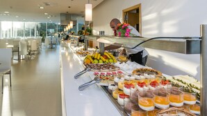 Un buffet proposant une variété de plats et une personne qui sert les clients.