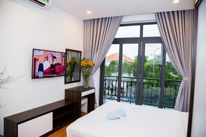 A hotel room with a bed, a TV on the wall, a desk, and a balcony with a view. - Melow Riverview Apartment (Ho Chi Minh City)