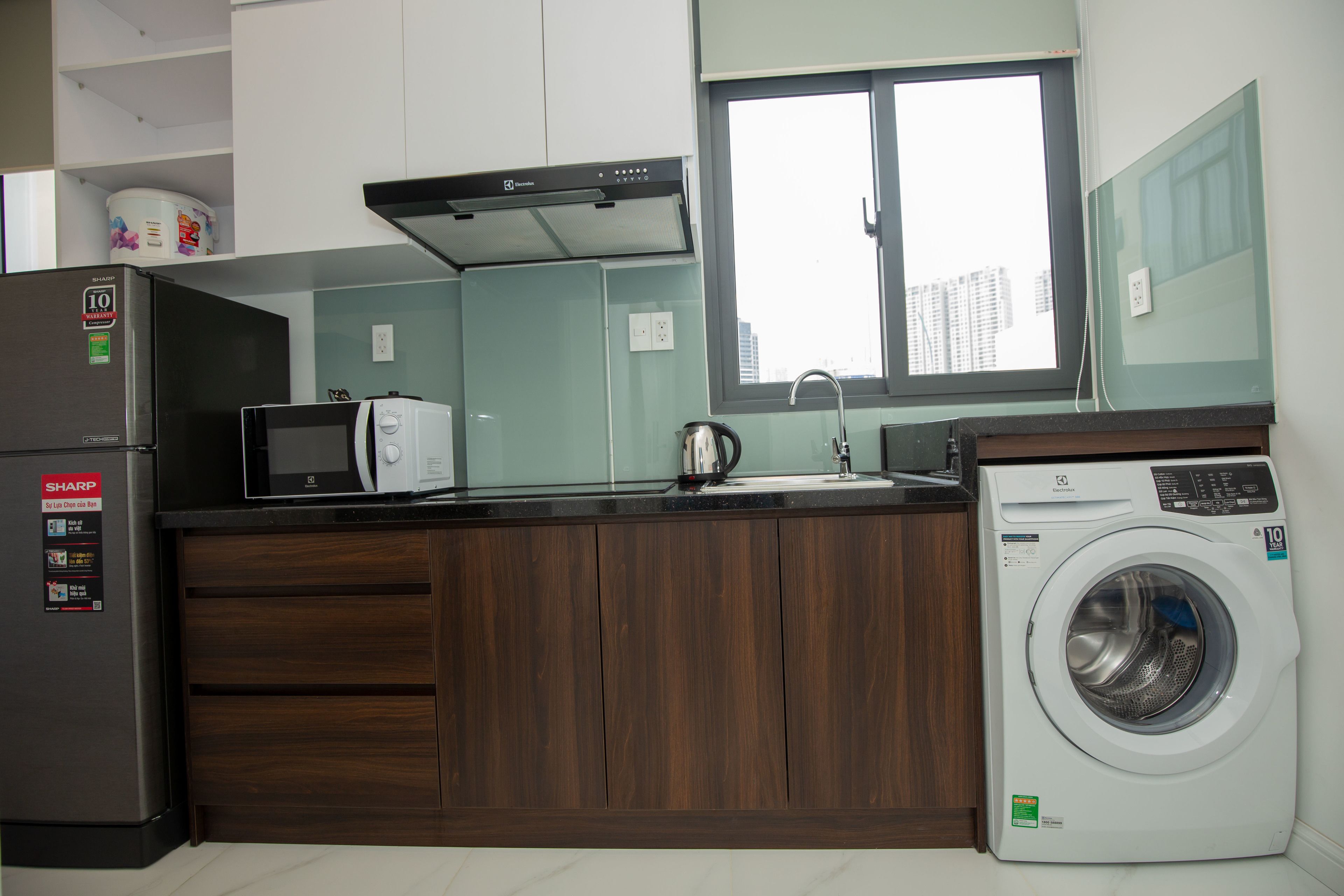 A compact kitchen with a microwave, toaster, and washing machine.