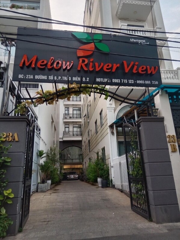 A hotel entrance with a sign reading "Melow River View" and contact details. - Melow Riverview Apartment (Ho Chi Minh City)
