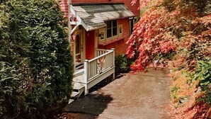 A red wooden house with a porch and a covered walkway.