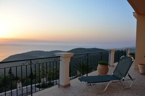 A balcony with a view of a mountainous landscape during sunset. - Villa Fantasia (Kefalonia)