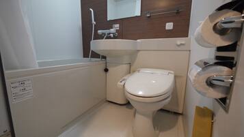 A small, compact bathroom with a toilet, sink, and shower.