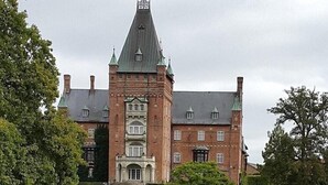A large, historic building with a prominent tower and multiple windows. - Hotel Stensson (Eslöv)