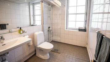 Un baño moderno con inodoro, lavabo y ducha.