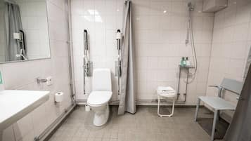 A modern bathroom with a toilet, shower, and a bench.
