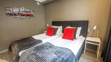 Habitación de hotel con una cama grande, dos mesitas de noche, una lámpara de pared y un cuadro en la pared.