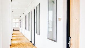 A long hallway with patterned carpet, white walls, and doors with black frames. - 7s Hotel An Phú Central (Ho Chi Minh City)