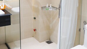 A modern bathroom with a glass-enclosed shower, a white toilet, and a sink with a mirror. - 7s Hotel An Phú Central (Ho Chi Minh City)