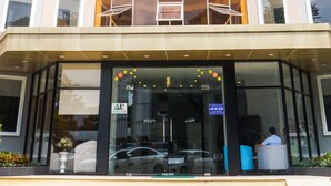 A modern hotel with a curved facade, multiple windows, and a glass entrance. - 7s Hotel An Phú Central (Ho Chi Minh City)