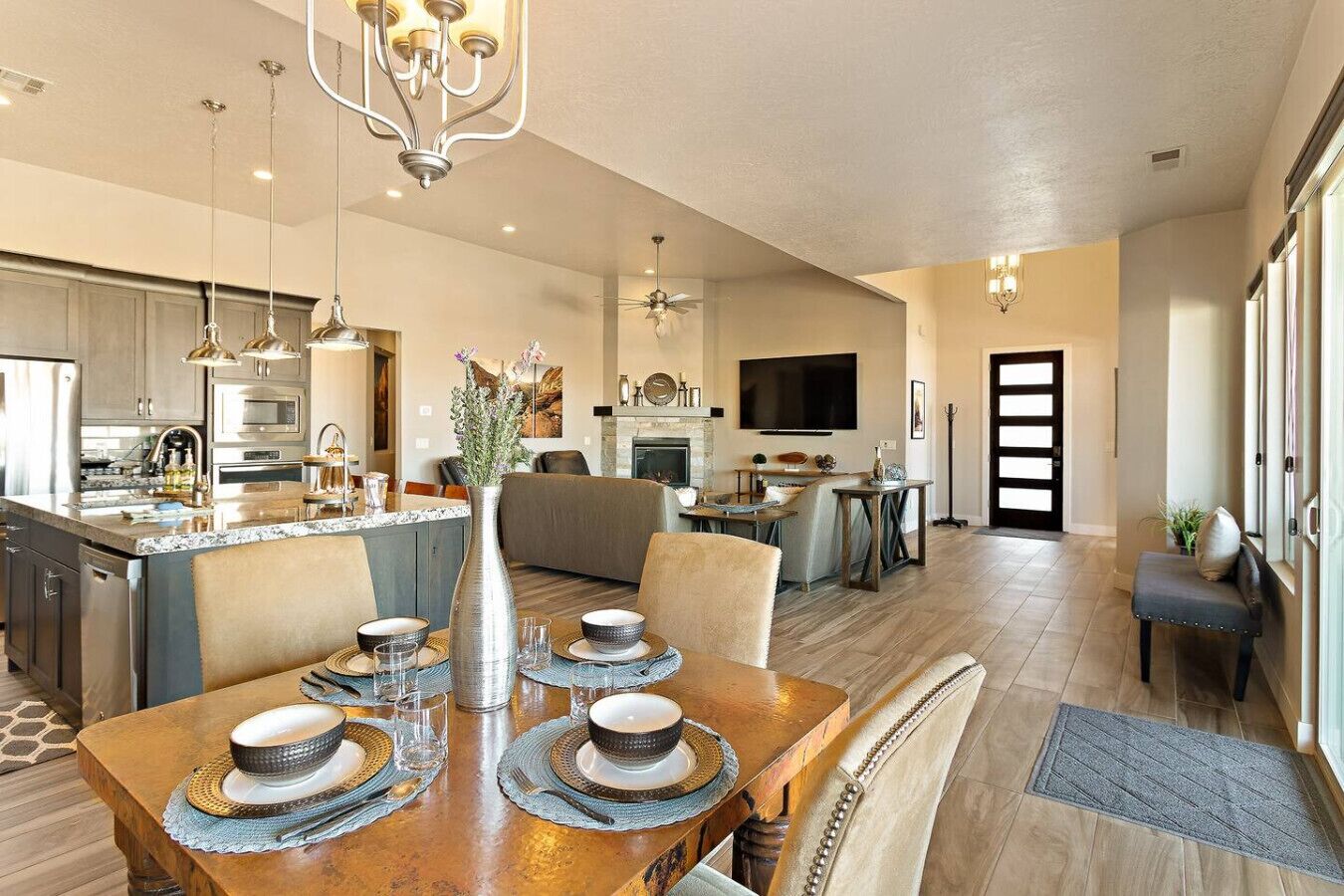 A spacious kitchen with modern appliances, a dining area with a wooden table set for four, and a living area with a fireplace.