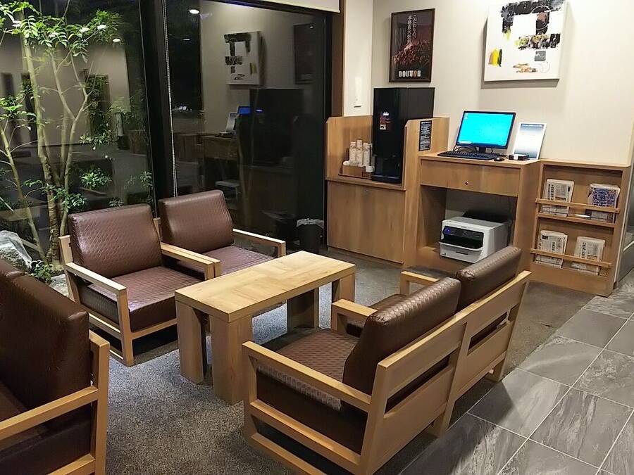 A modern interior with leather seating, a wooden table, and a computer setup.