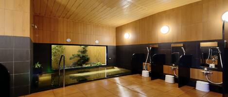 A modern bathroom with wooden paneling, a glass partition, and multiple sinks.