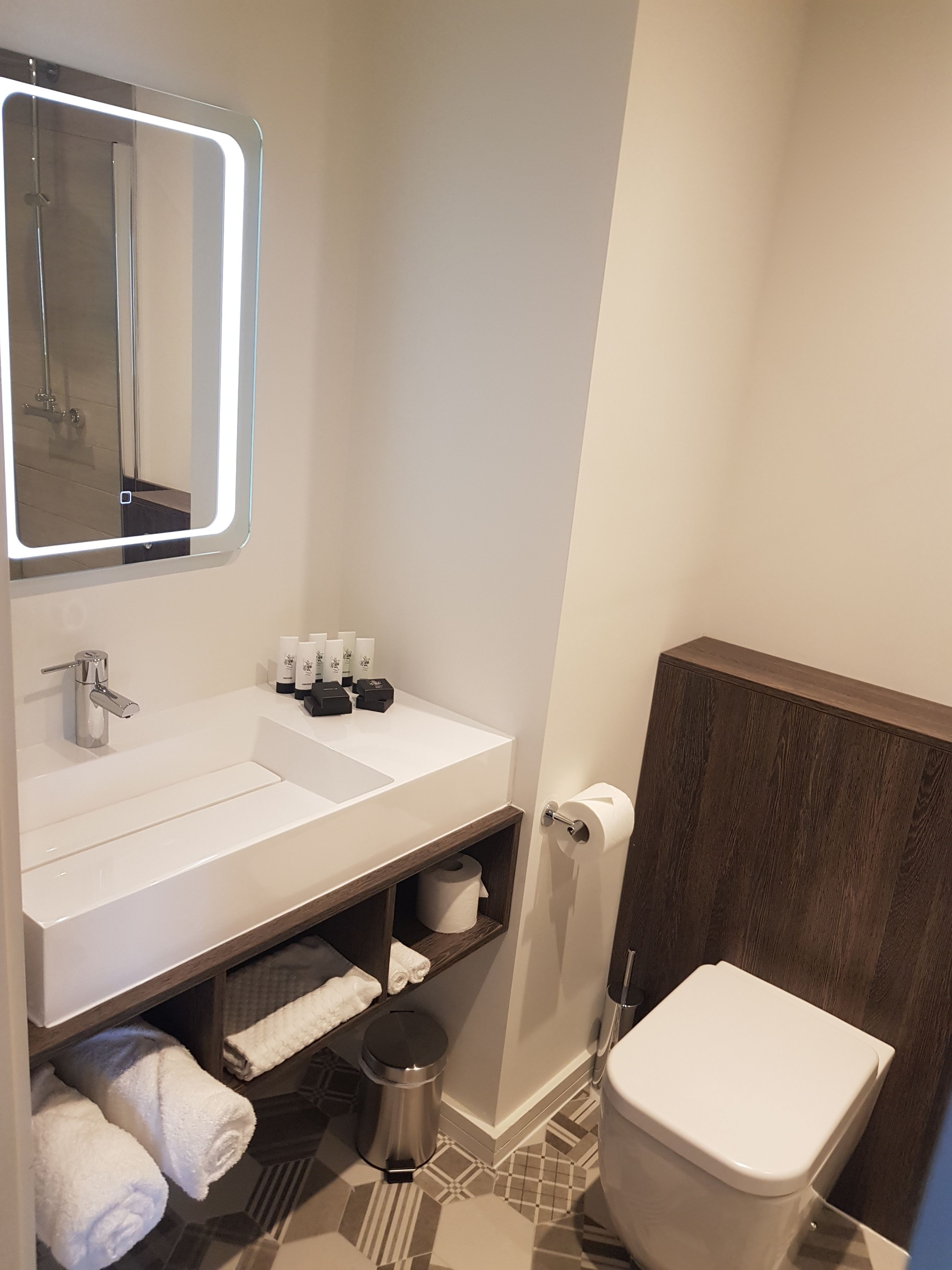Signature studio suite | Badkamer | Een douche, een haardroger, handdoeken, zeep