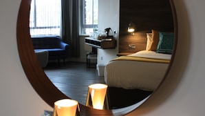 A hotel room with a bed, bedside table, lamp, and a chair. - Base Accommodation Dingle (Dingle)