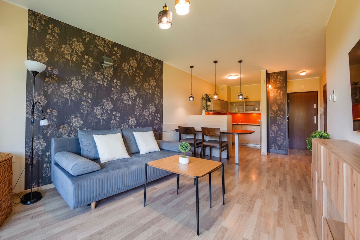 Ein modernes Wohnzimmer mit einer Couch, einem Couchtisch und einem Essbereich mit Tisch und Stühlen.