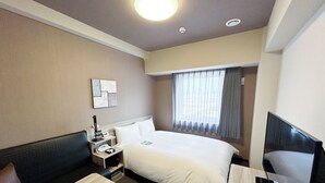 A hotel room with a bed, a desk, a chair, a TV, and a window with curtains. - Hotel Route-Inn Takefu Inter (Echizen)
