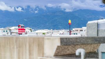 A view of a coastal town with a prominent red and white building, a McDonald's sign, and a mountain in the background.