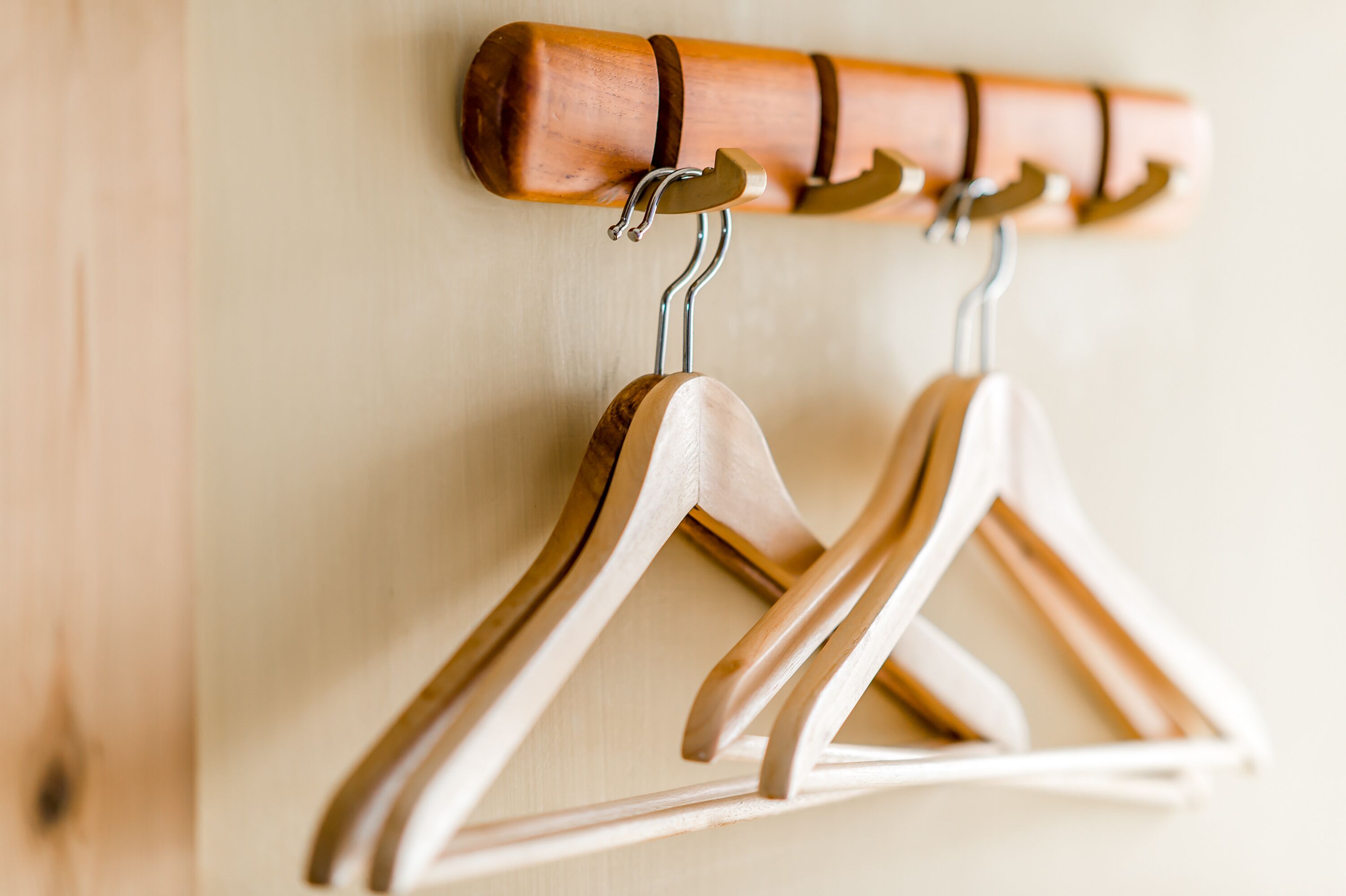 A wooden coat rack with several wooden hangers.